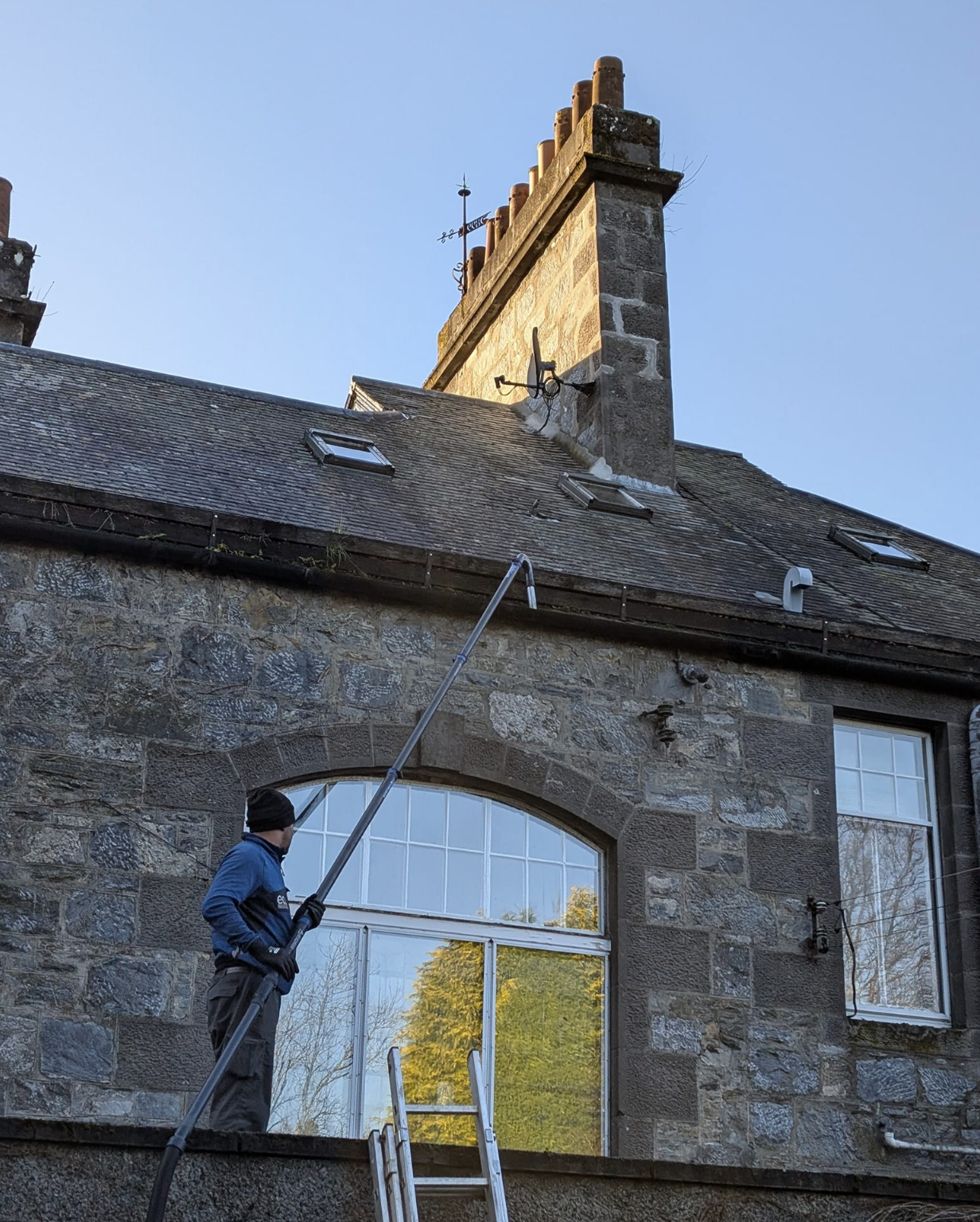 Gutter cleaning service on traditional Scottish stone building